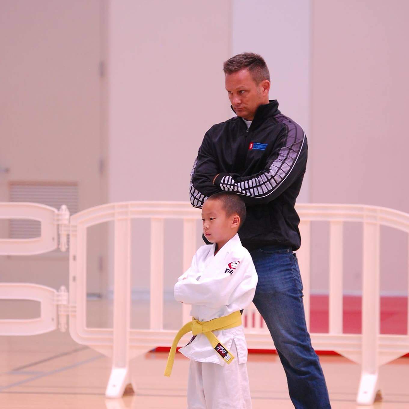 Brent standing on the mat in a white judogi, mid-class